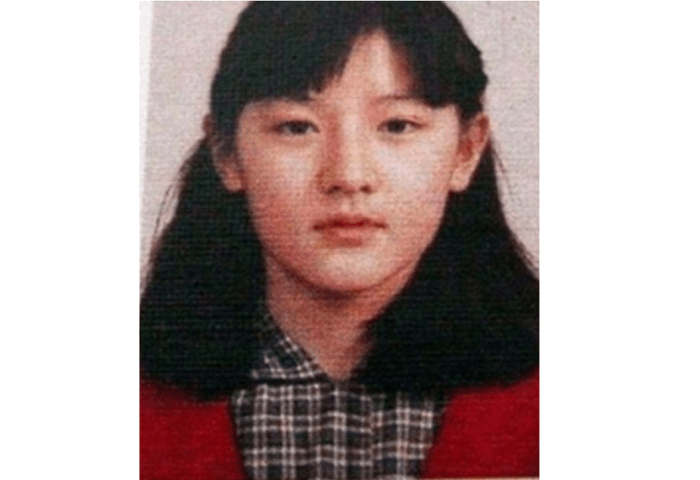 韓国女優イ・ヨンエの小学校の卒業アルバム写真。
黒っぽいチェックのシャツに赤色のカーディガンを着用している。
髪はミディアムヘアで前髪は眉にかかる程度の長さ。