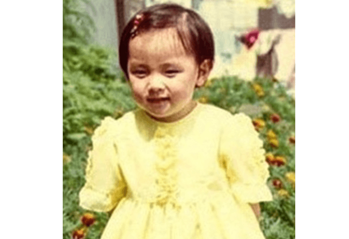 韓国女優イ・ヨンエの幼少期（3歳頃）の画像。
ショートカットで前髪をピンでとめており、黄色のフリルのついたワンピースを着て笑っている。
可愛らしい女の子の画像。